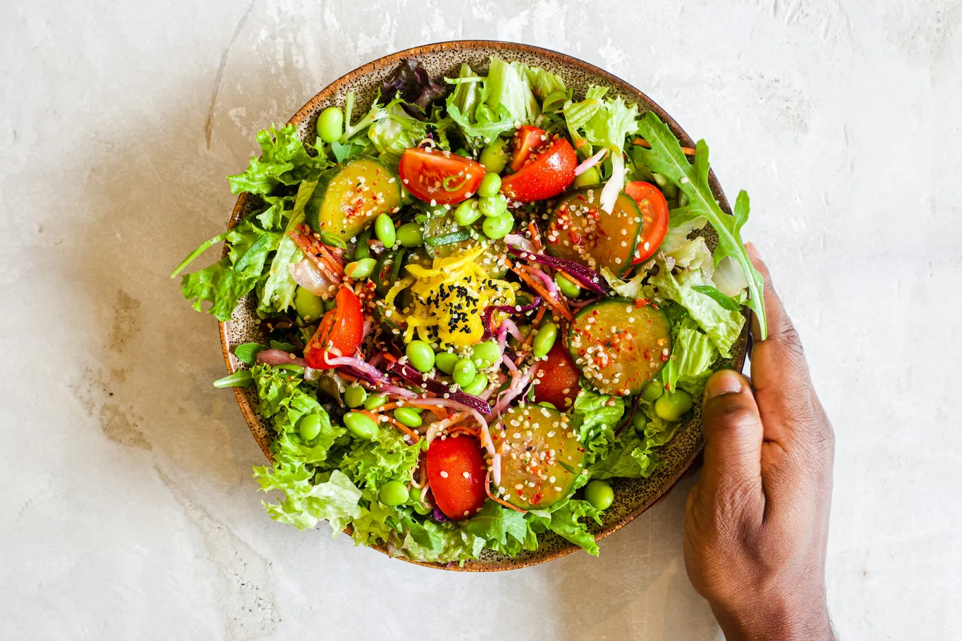 Salada de folhas verdes com tomate, edamame e sementes.